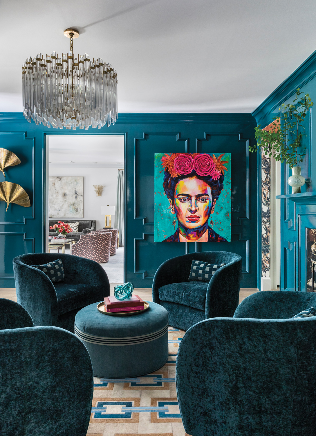 Turquoise sitting area with glam chandelier and frida kahlo art