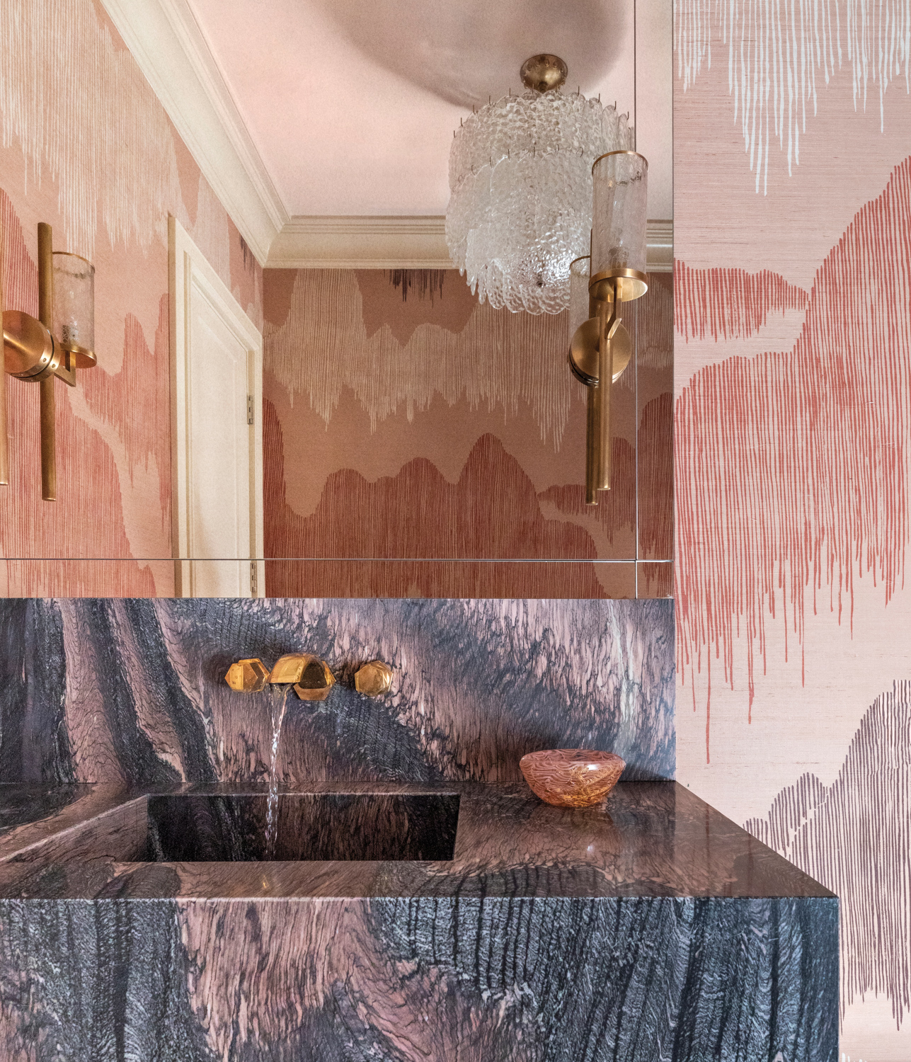 powder room with richly veined marble and complementary wallpaper