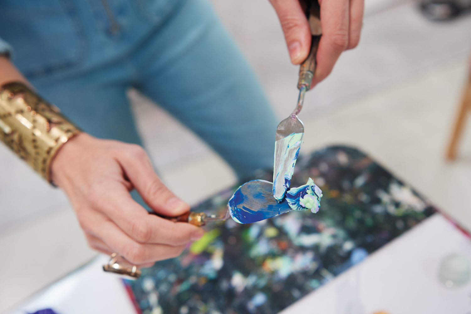 artist sculpting oil paints on palette knife