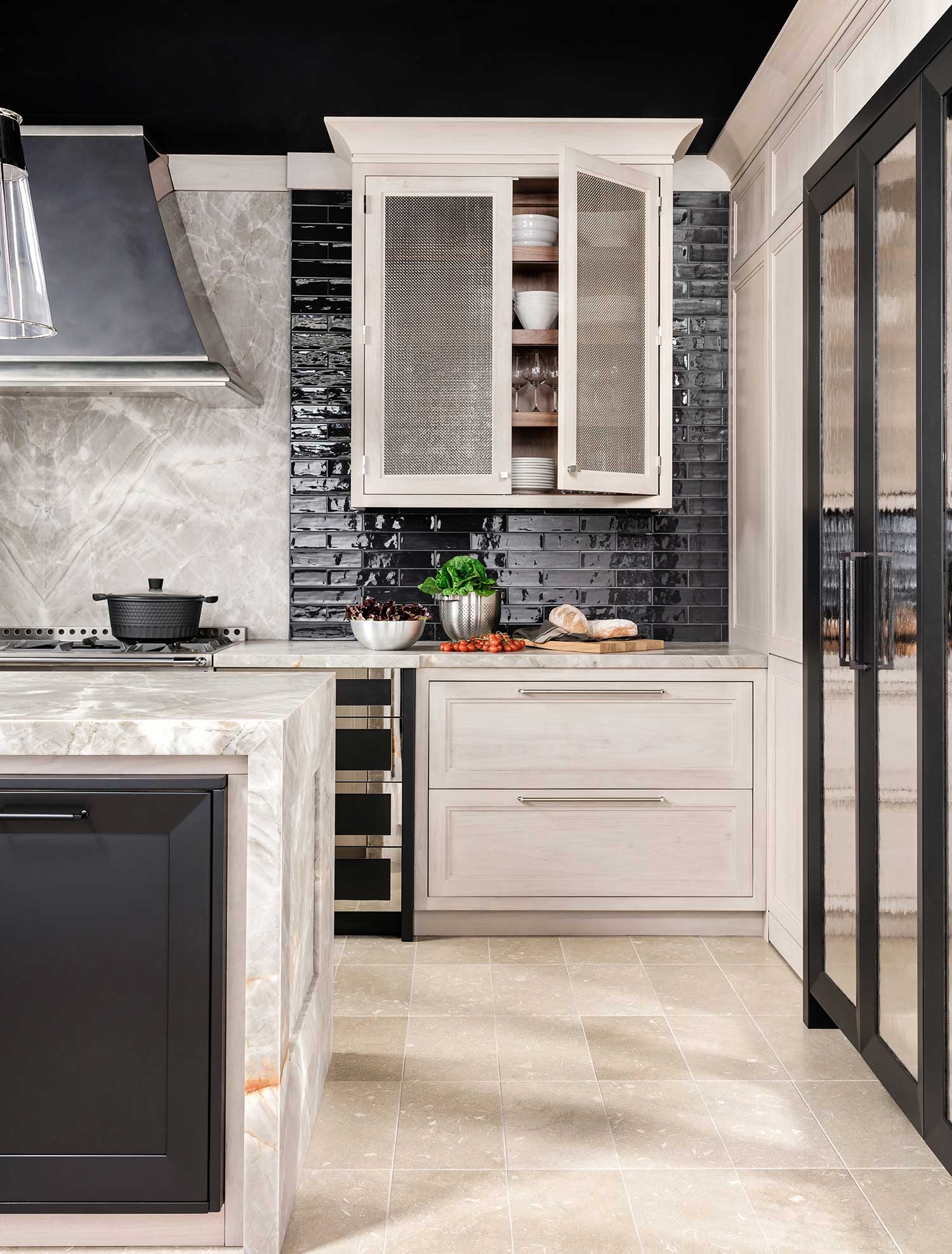 kitchen vignette with black glazed tile backsplash, white cabinetry and white marble countertops