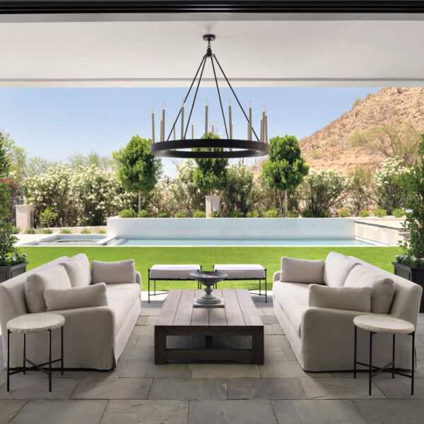 Contemporary Lines And A Sleek Palette Transform A Desert Home Stone Patio Overlooking A Pool With Two White Couches And A Coffee Table