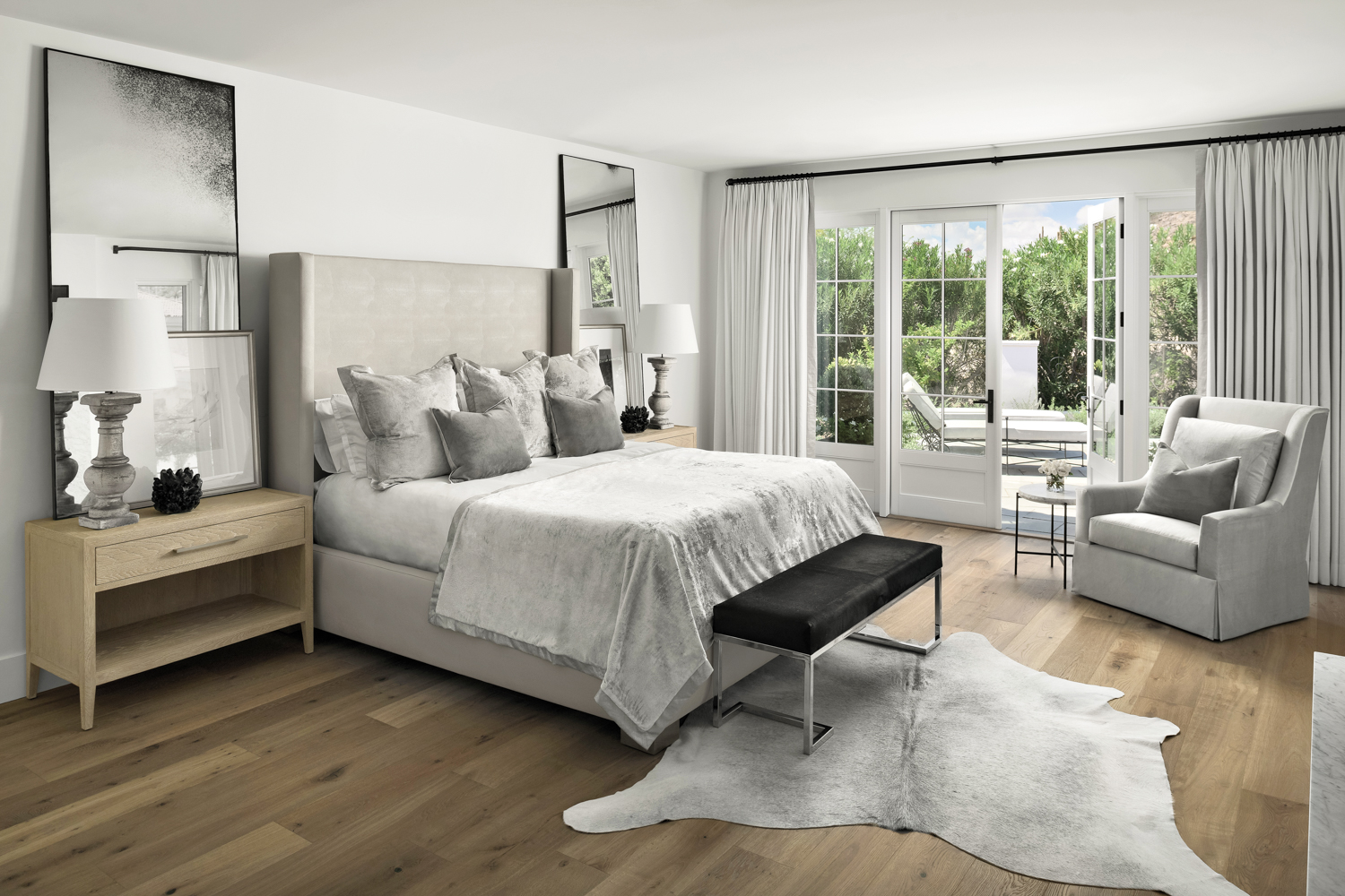 A white bedroom with gray furniture, silvery bedding and animal skin throw rug.