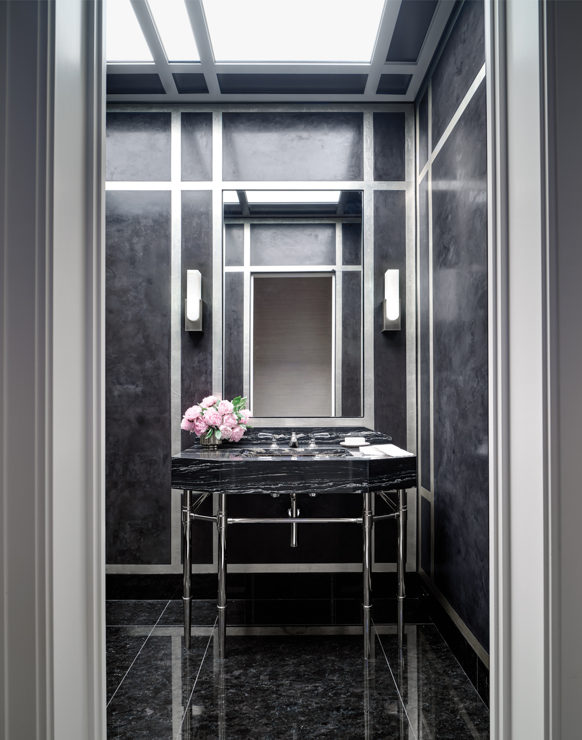 A black-and-silver powder room with...