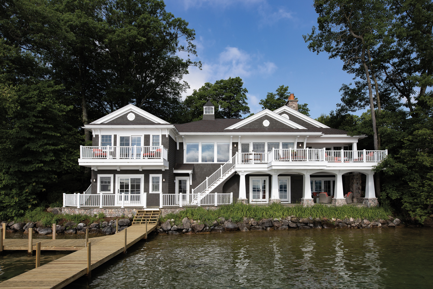 A lakefront shingle-style house with...