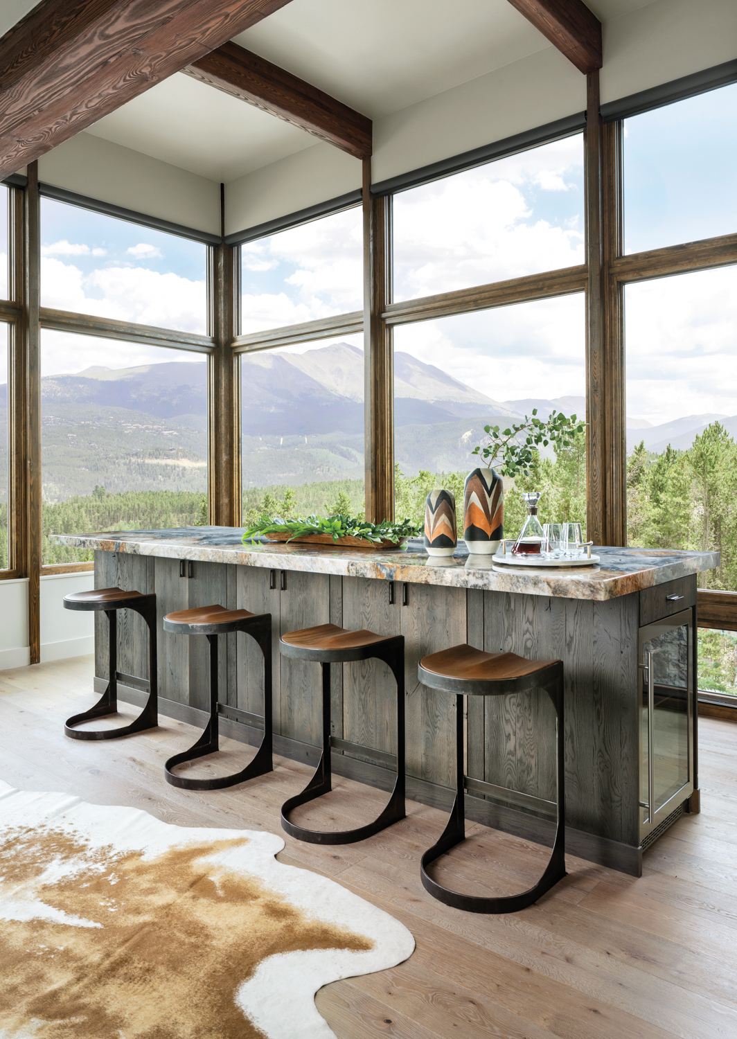 bar seating with white oak wood island against a wall of windows showing mountain views