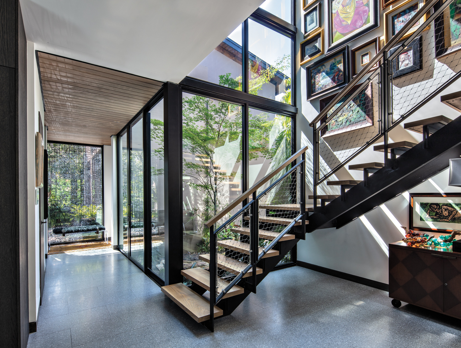wellness room entry with glass walls, modern staircase and terrazzo flooring