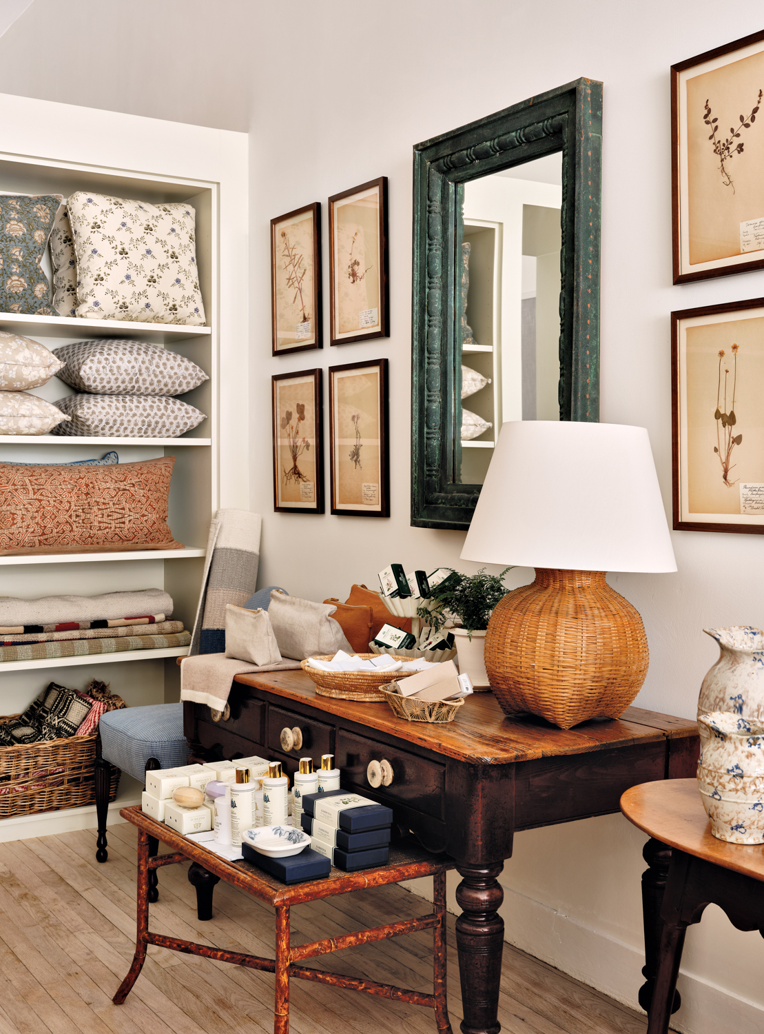 McGrath II boutique interior feature rattan table lamp, pillows on a shelves, toiletries and wall decor