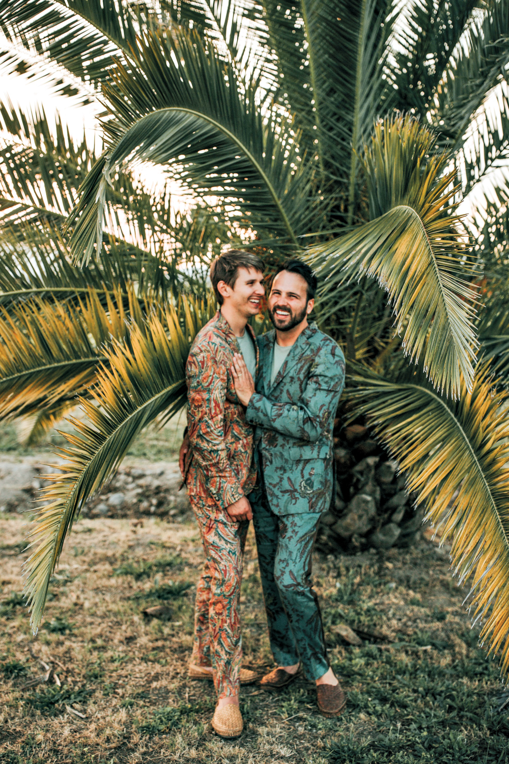 Outdoor portrait of designers Austin Carrier and Alex Mutter-Rottmayer in front of a palm tree.