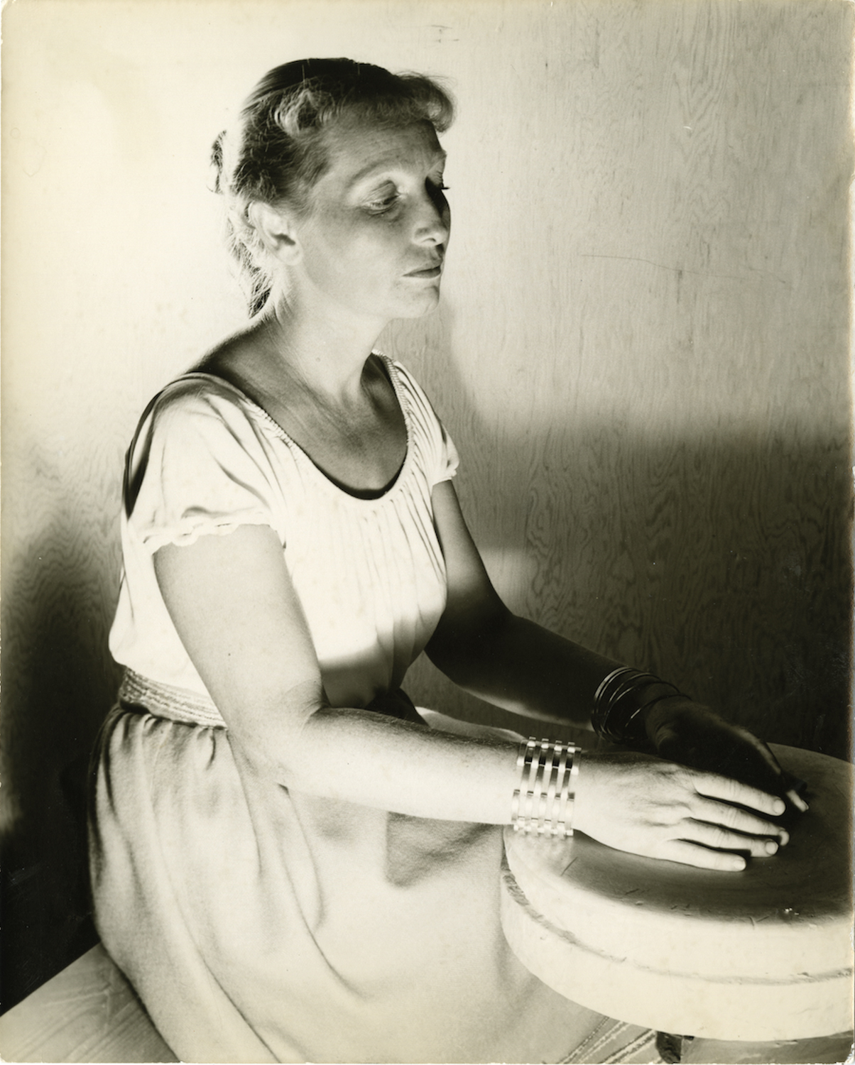 Black and white portrait of Edith Heath of Heath Ceramics at the pottery wheel.