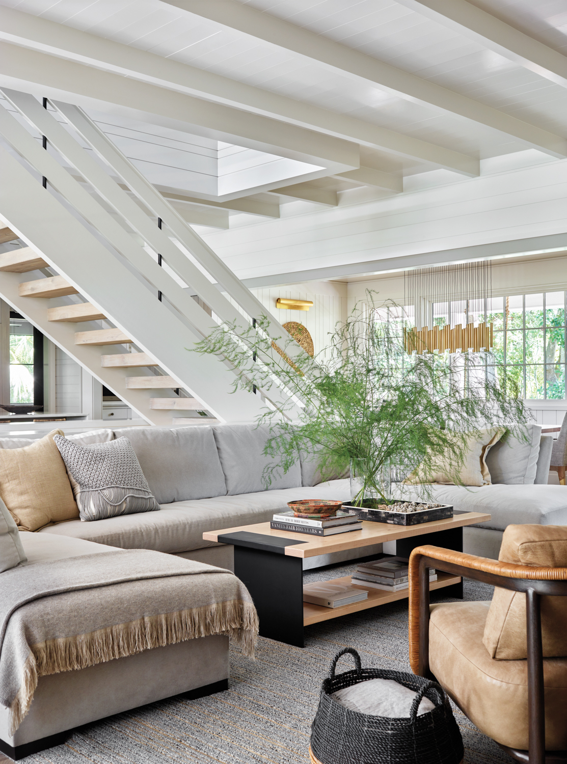 Open-format living space with oversize sectional and prominent staircase