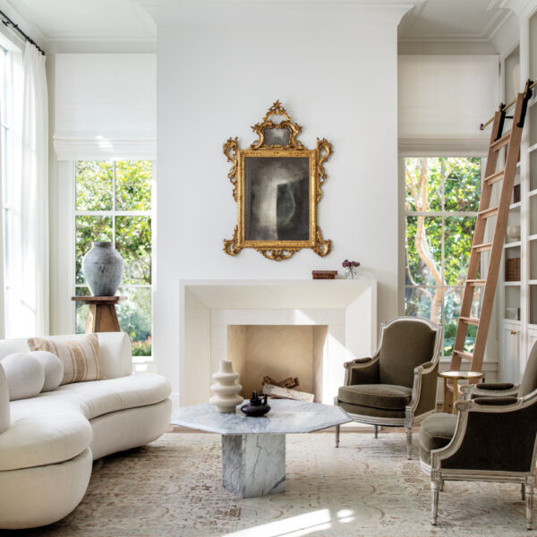 It’s All About The Mix In A Houston Home Inspired By New Orleans modern white parlor featuring a limestone mantel and antique furnishings