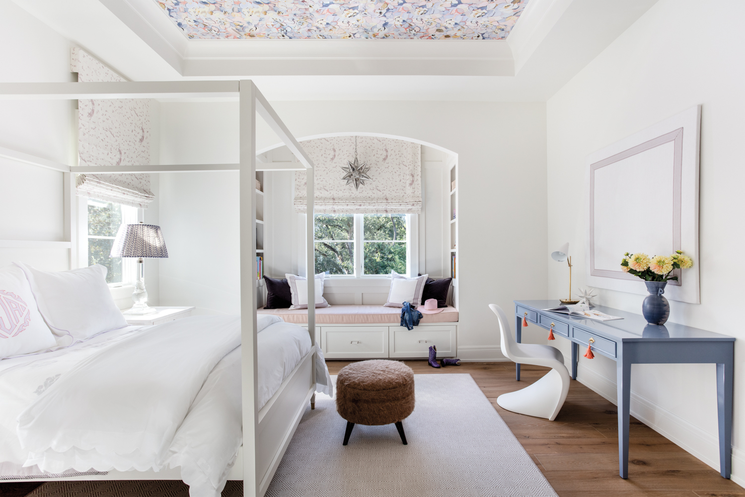 child's bedroom with a window seat and pattern-papered ceiling