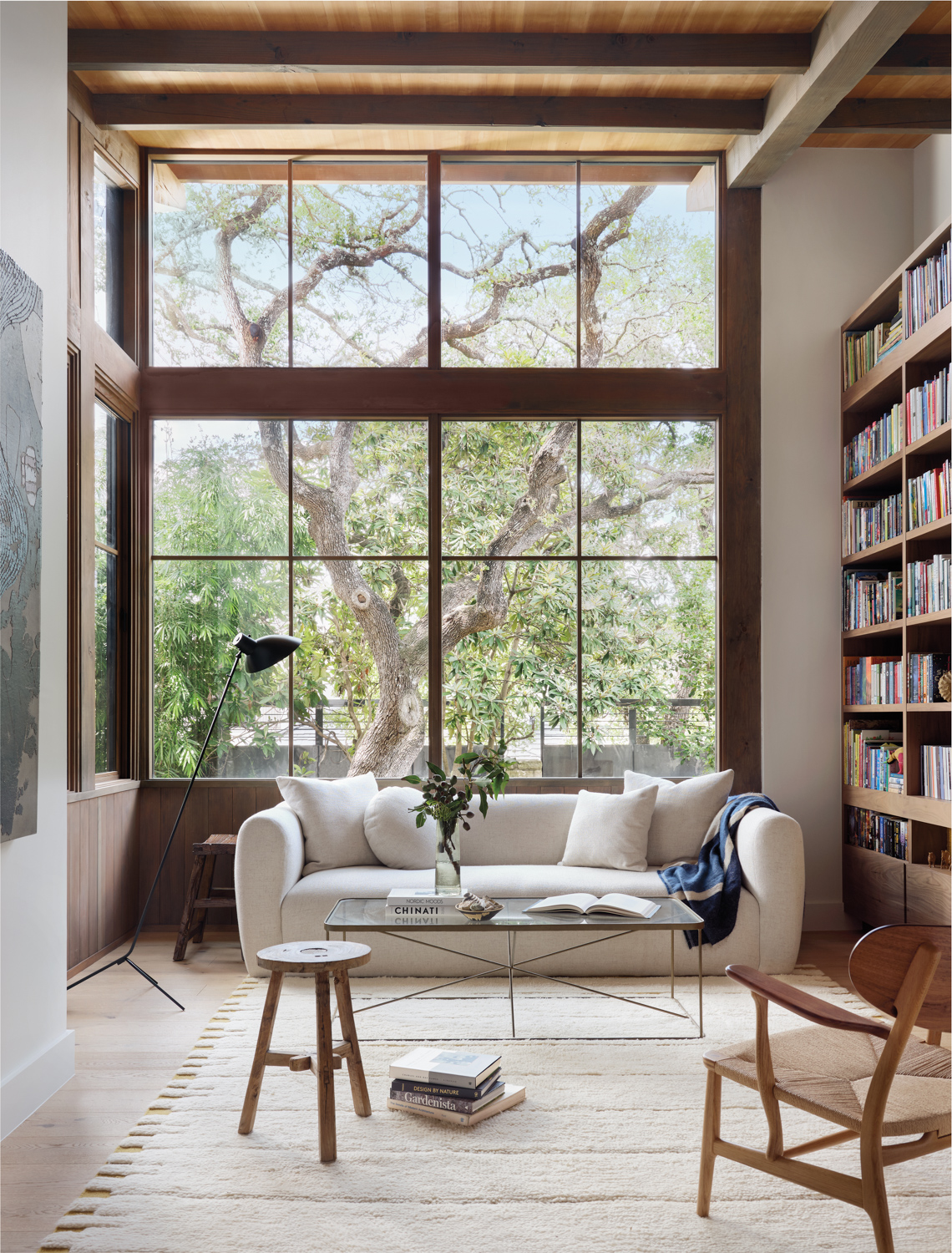 library with massive windows, bookshelves and a white sofa