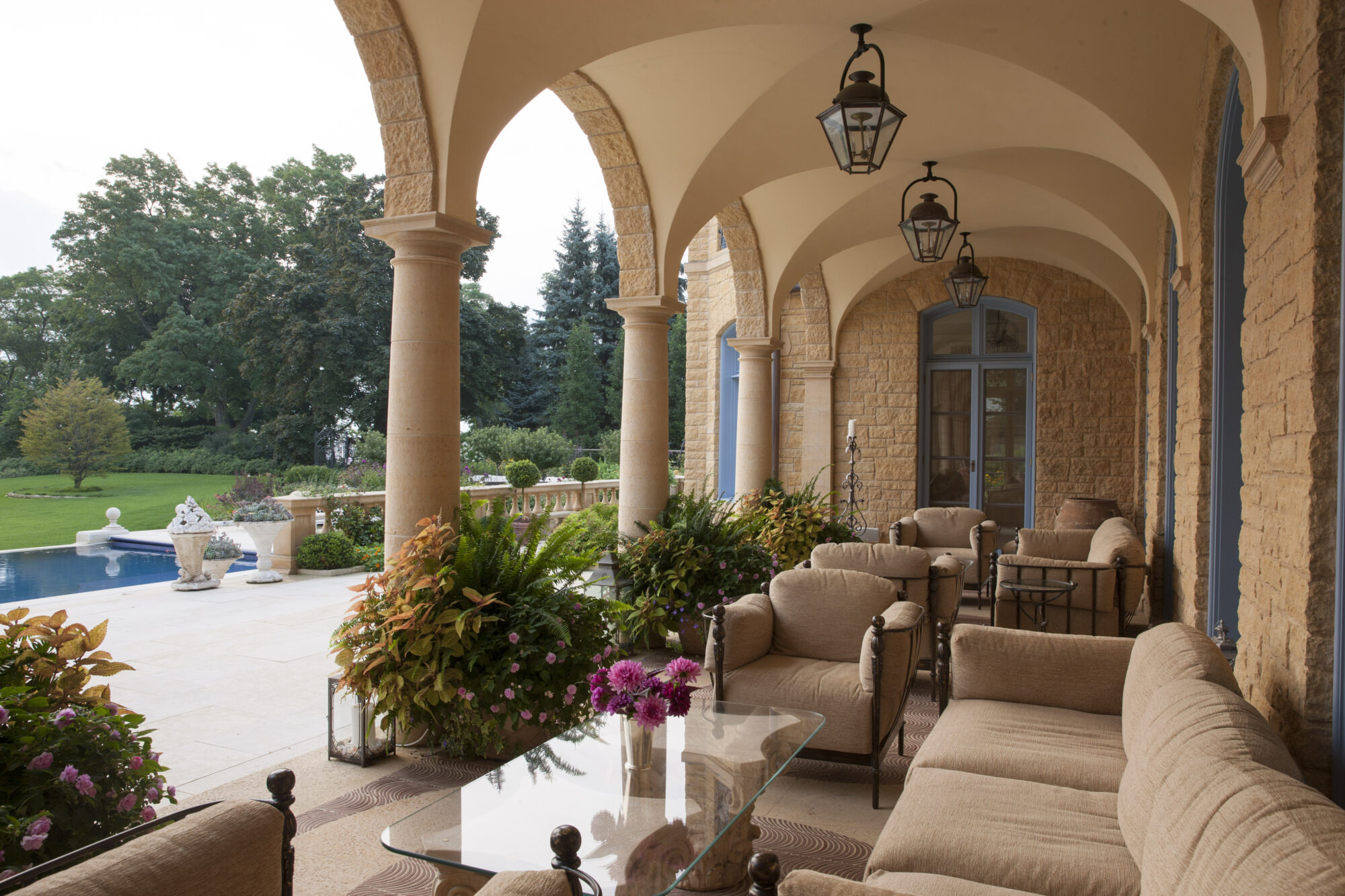 Traditional poolside loggia with hanging lanterns and multiple seating groups