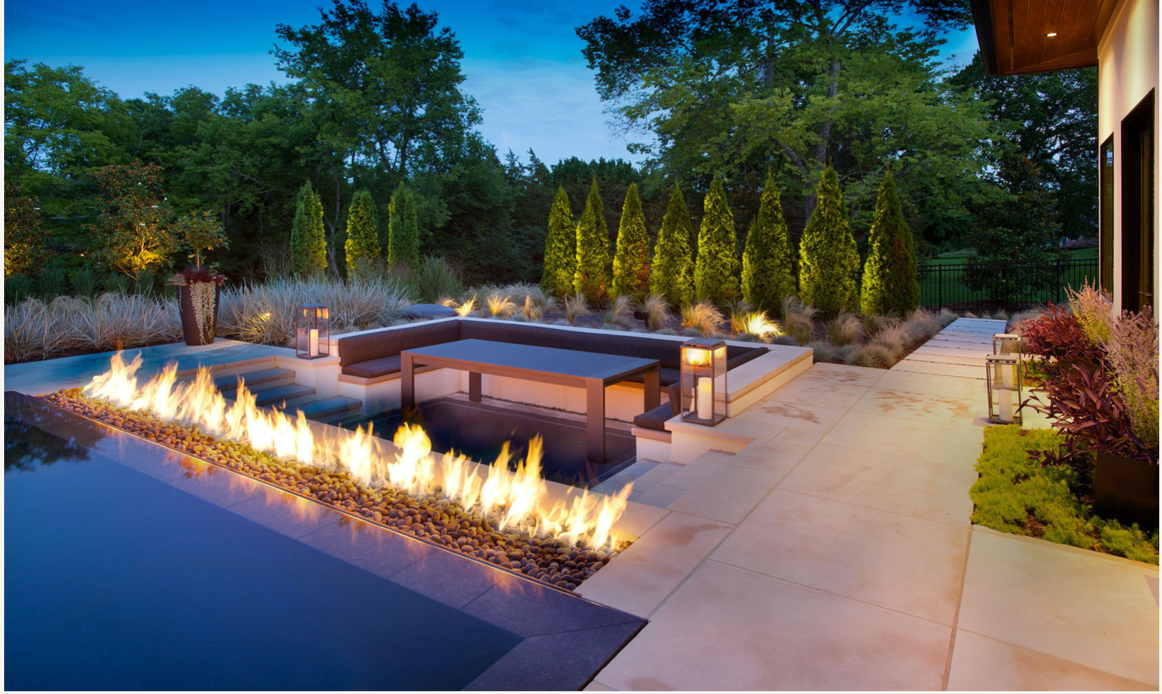 Outdoor space with pool, filter feature and cypress trees