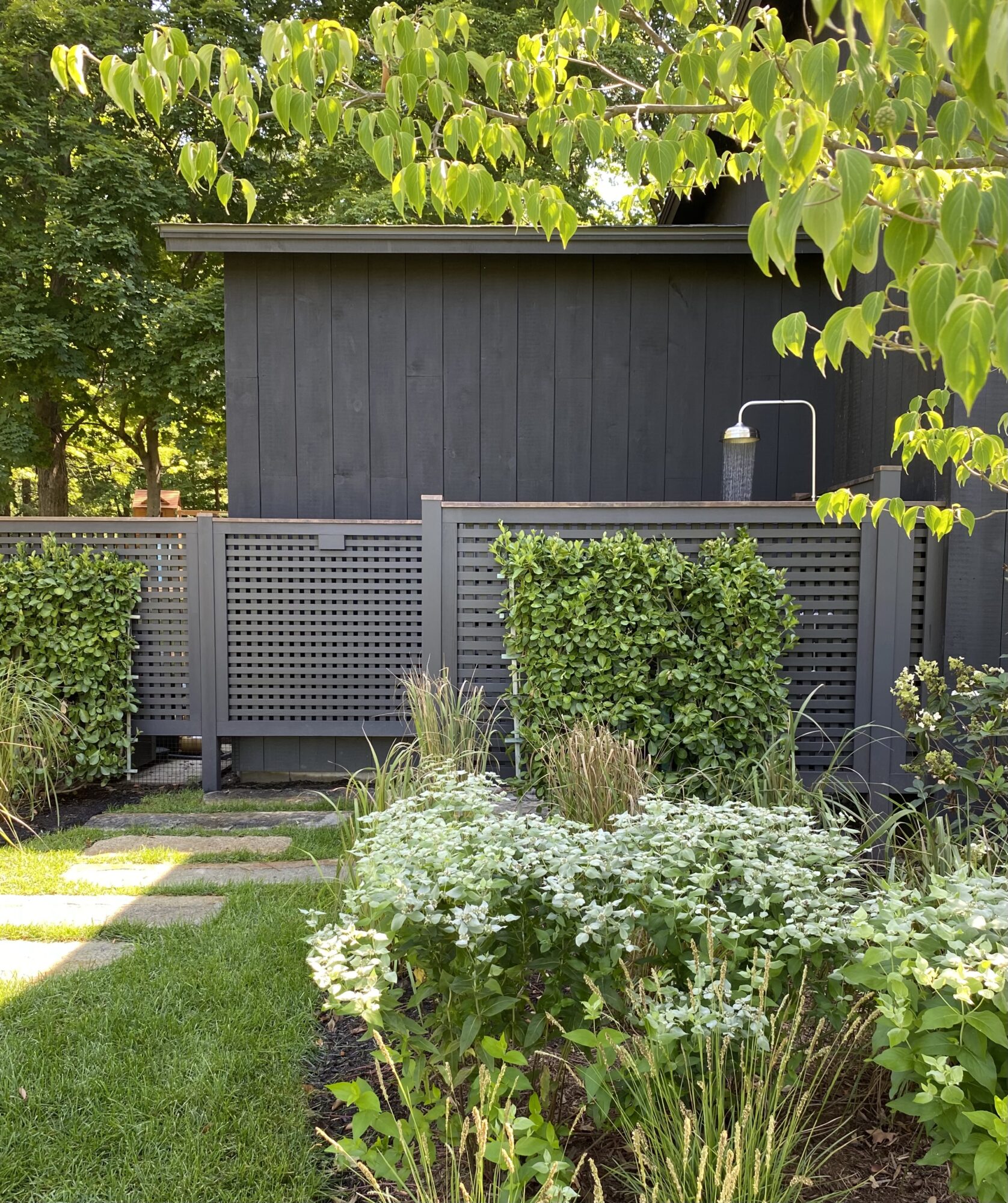 Dark gray building with privacy screen and outdoor shower