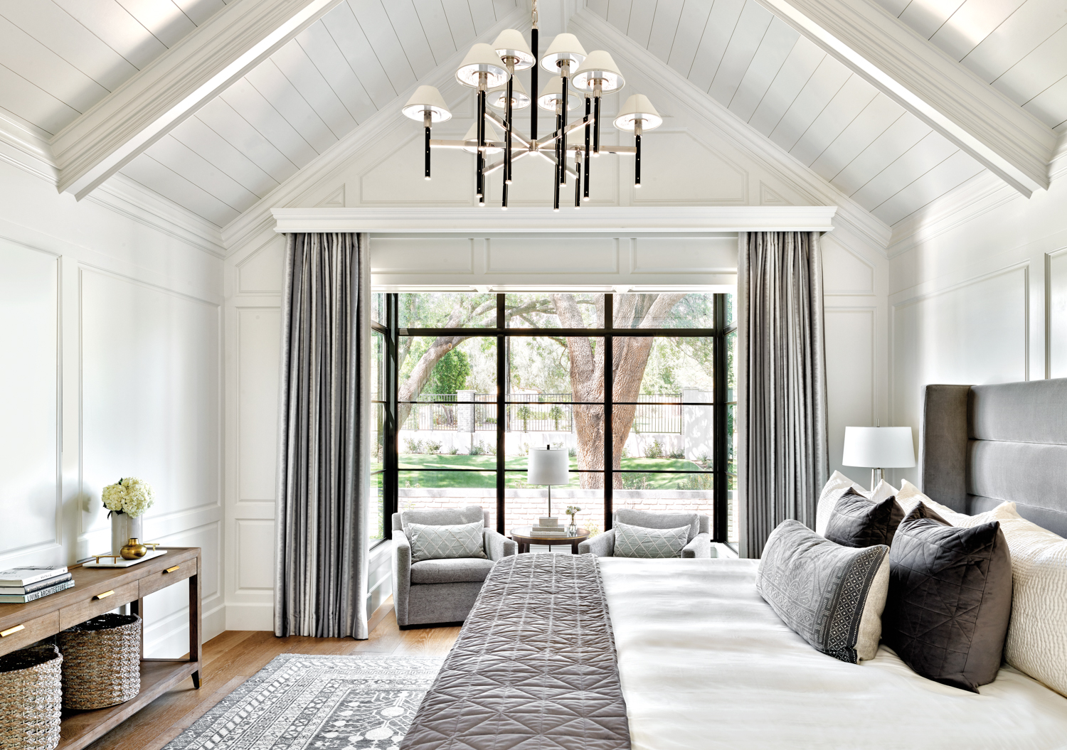 A gray-and-white bedroom with vaulted...
