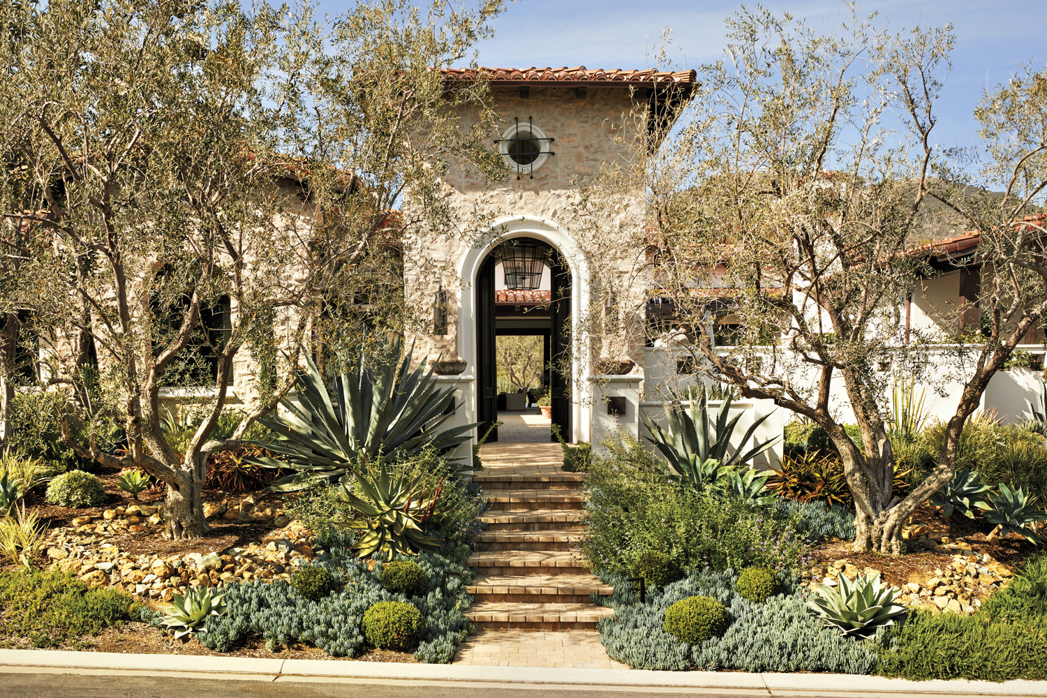 entryway path ro Mediterranean-style home with overgrout stone exterior