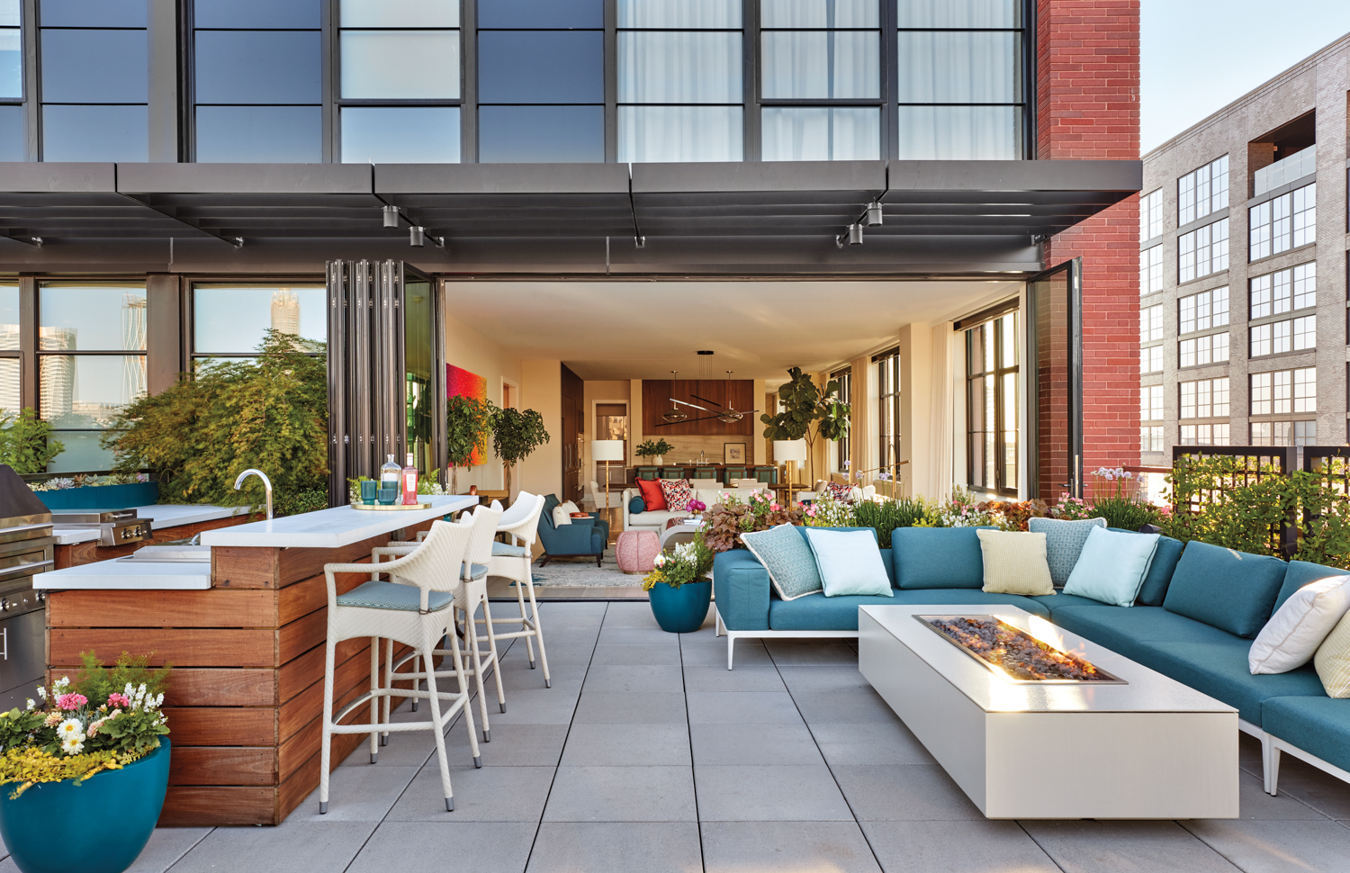 Urban patio with blue sectional, fire pit and ipe wood bar.