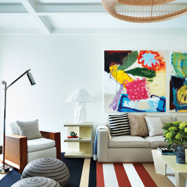 The Modern Southampton Family Compound With Colorful Surprises modern hamptons living room with vibrant wall art and patterned carpeting