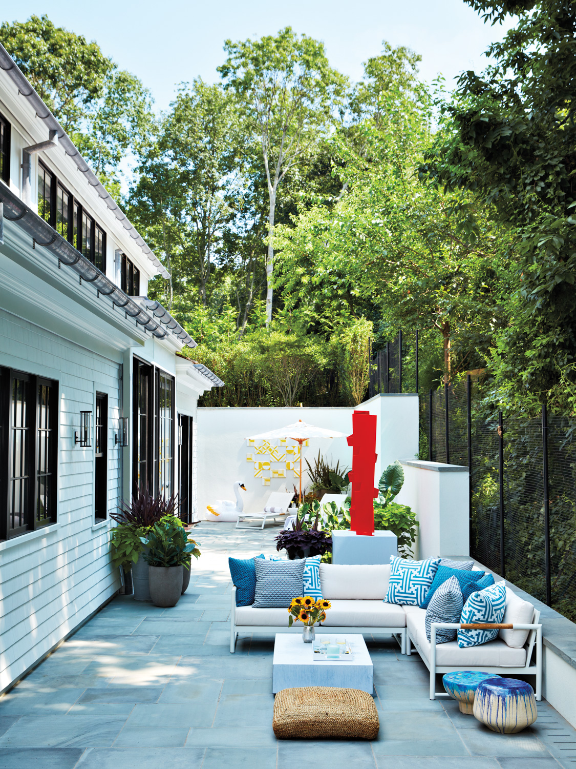 outdoor sitting area with white cushioned couch and patterned blue pillows
