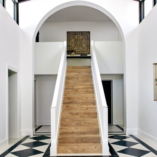 Madrid Comes To Miami Via This Historic Home Renovation porcelain wood staircase to courtyard with checkerboard flooring
