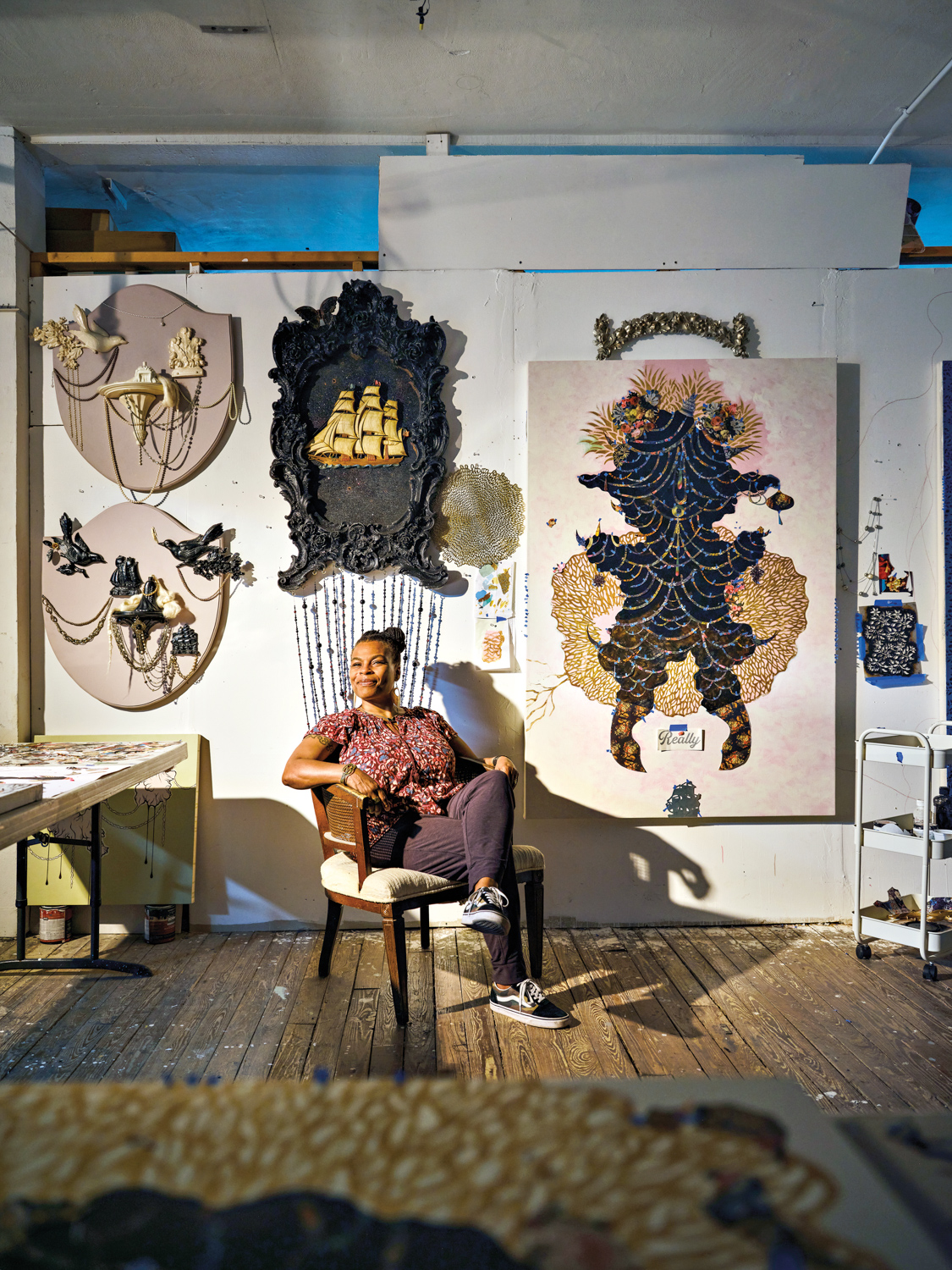 artist vickie pierre in her studio surrounded by her artwork