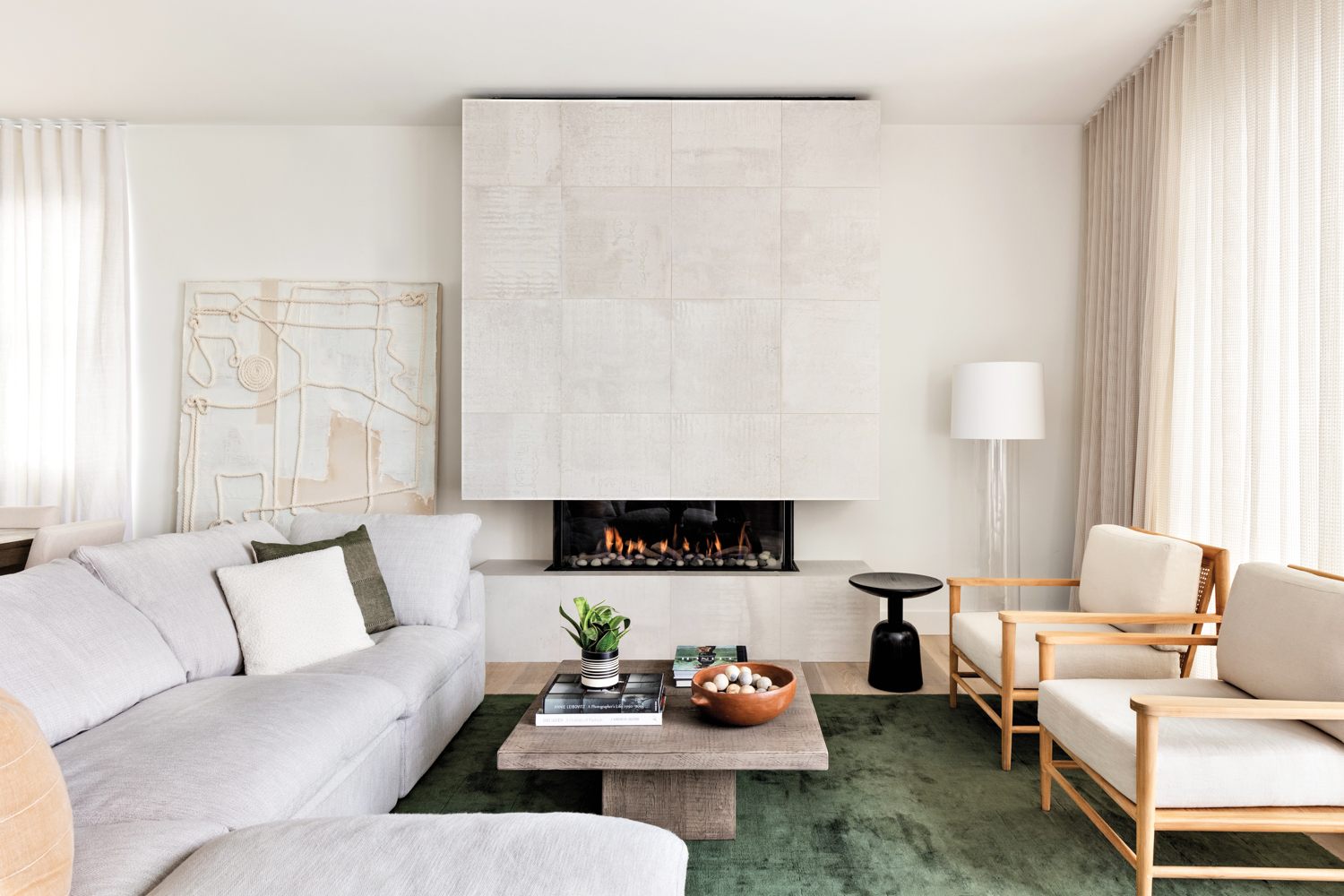 A fireplace is surrounded by white tile.
