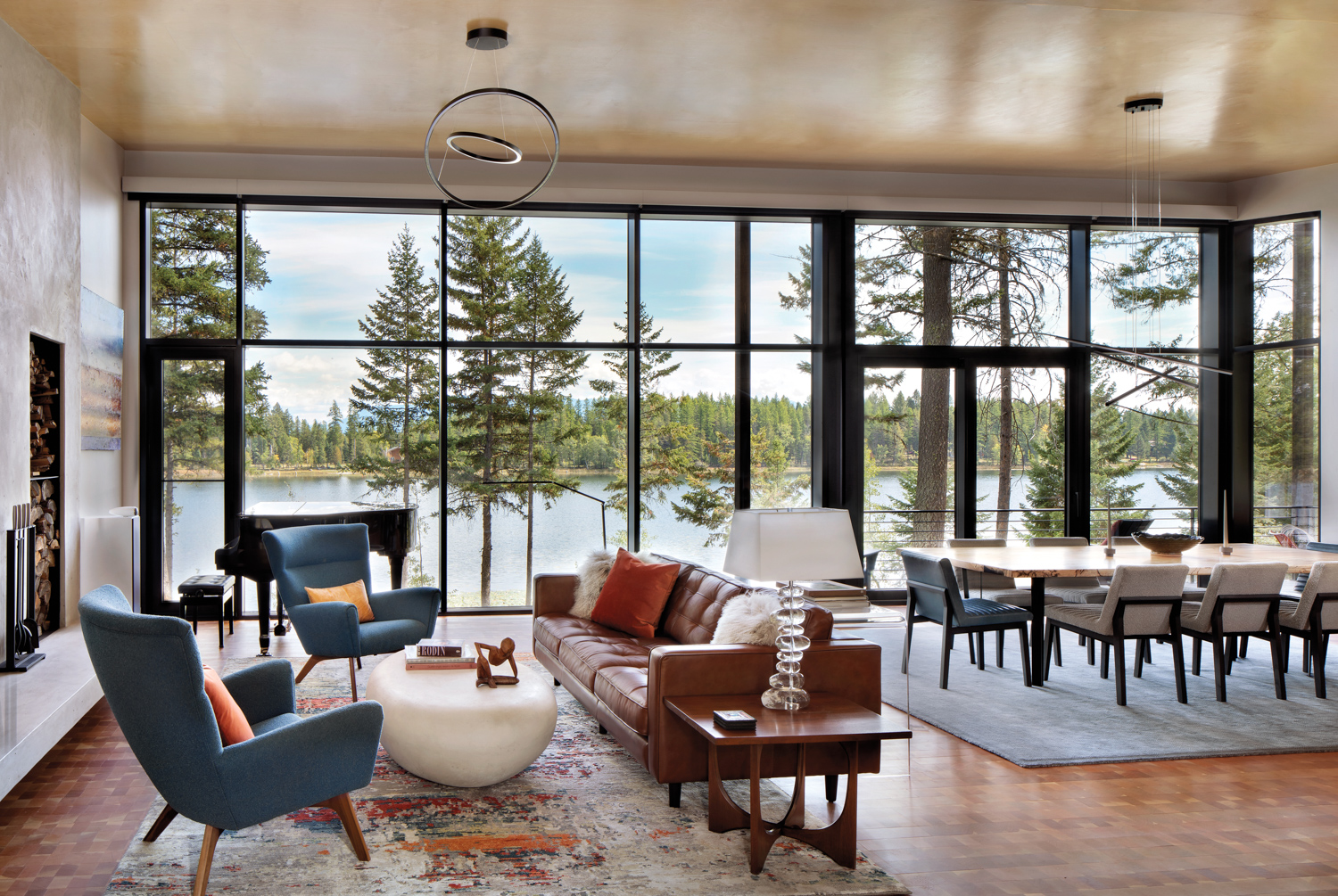 Large windows overlook a forested and water views.