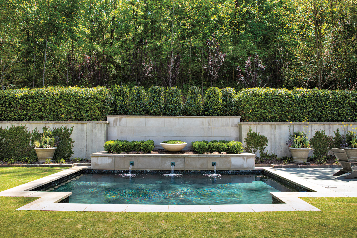 Swimming pool with fountain, trimmed grass lawn and boxwood border is the best garden inspiration