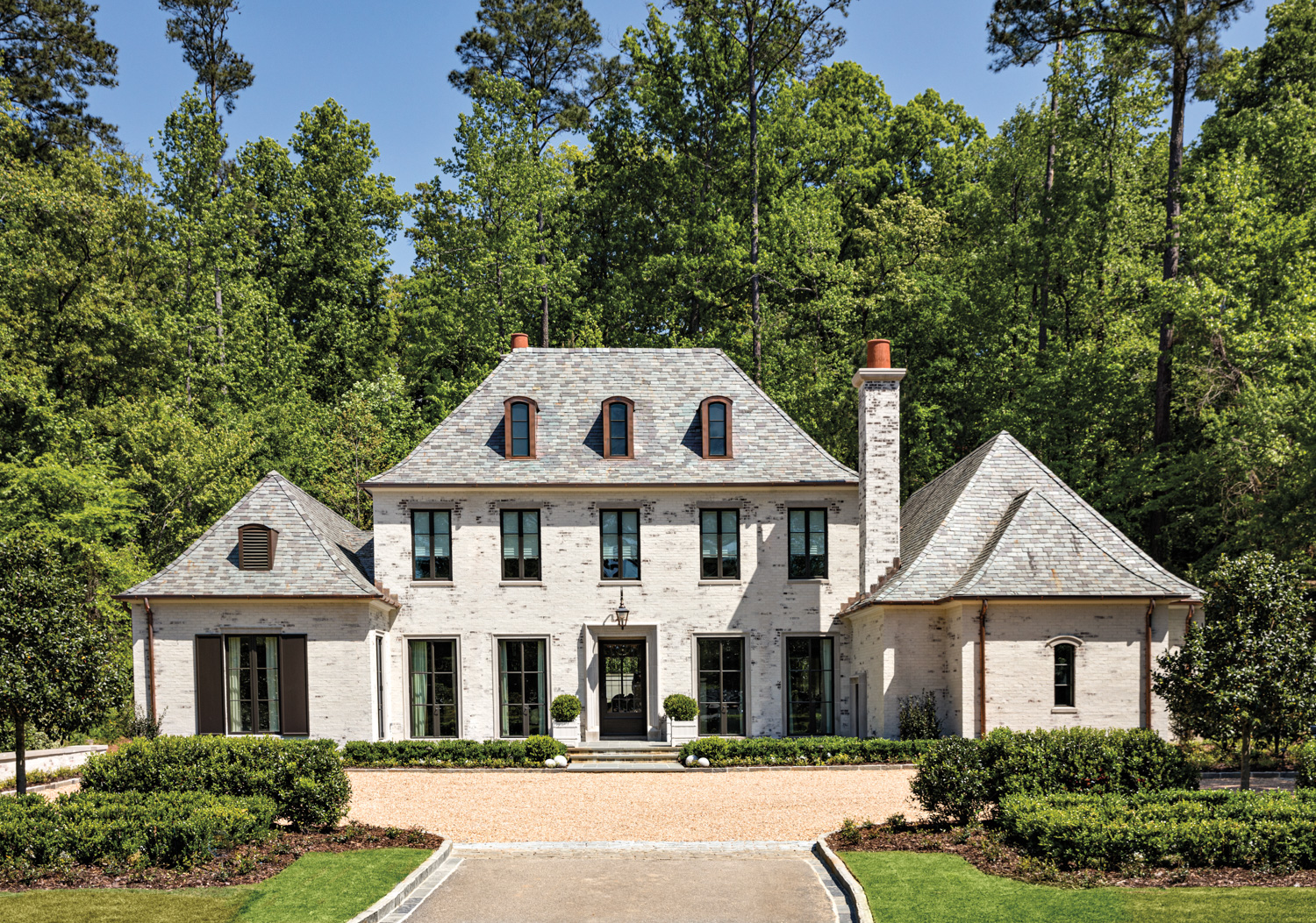 A formal and symmetrical French provincial-inspired residence with expansive motor court