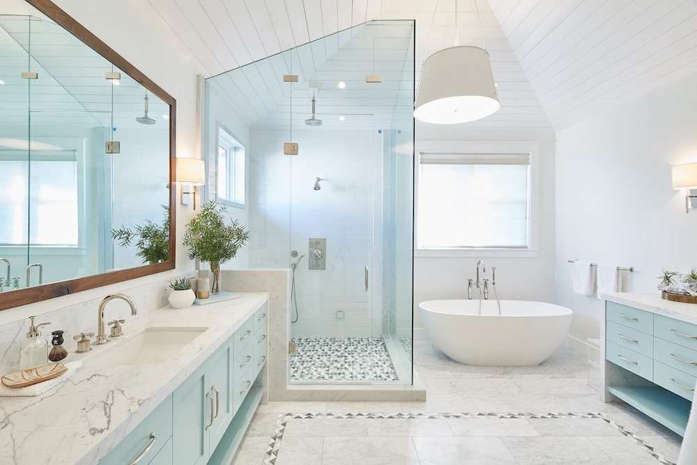 white bath room with tub and glass shower by Noelle Interiors