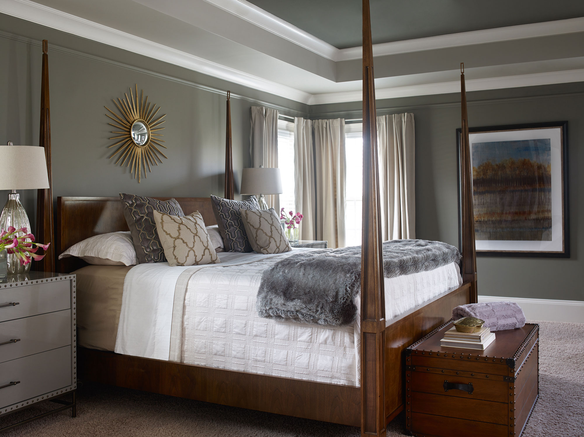 A gray bedroom with a wood four poster bed.