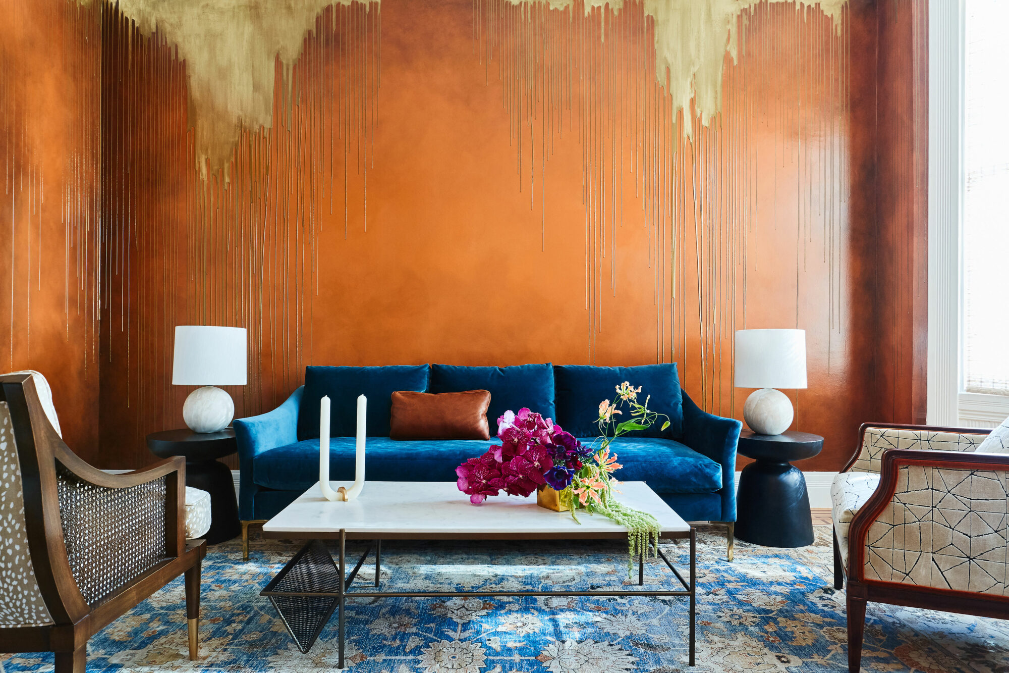 an orange living space with blue couch illustrates that complementary colors are hot for 2023