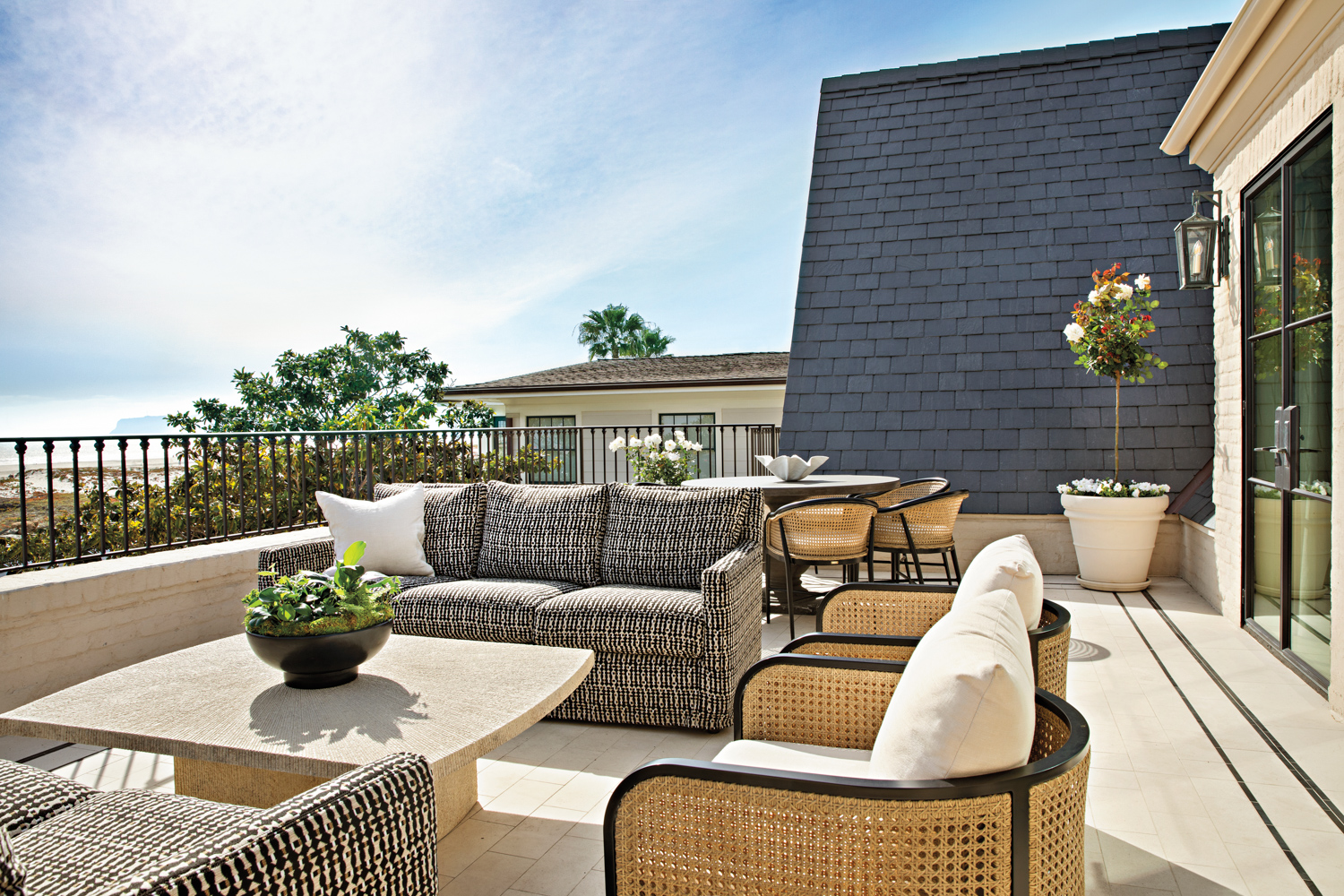 outdoor terrace with patterned sofas,...