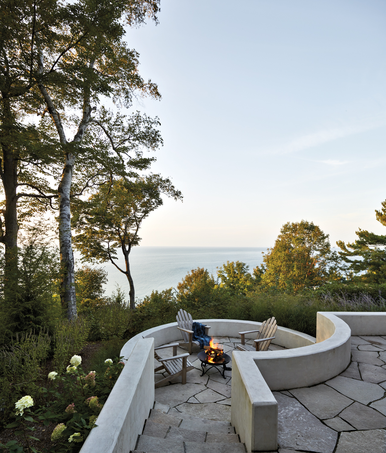 patio with a fire pit overlooking a lake