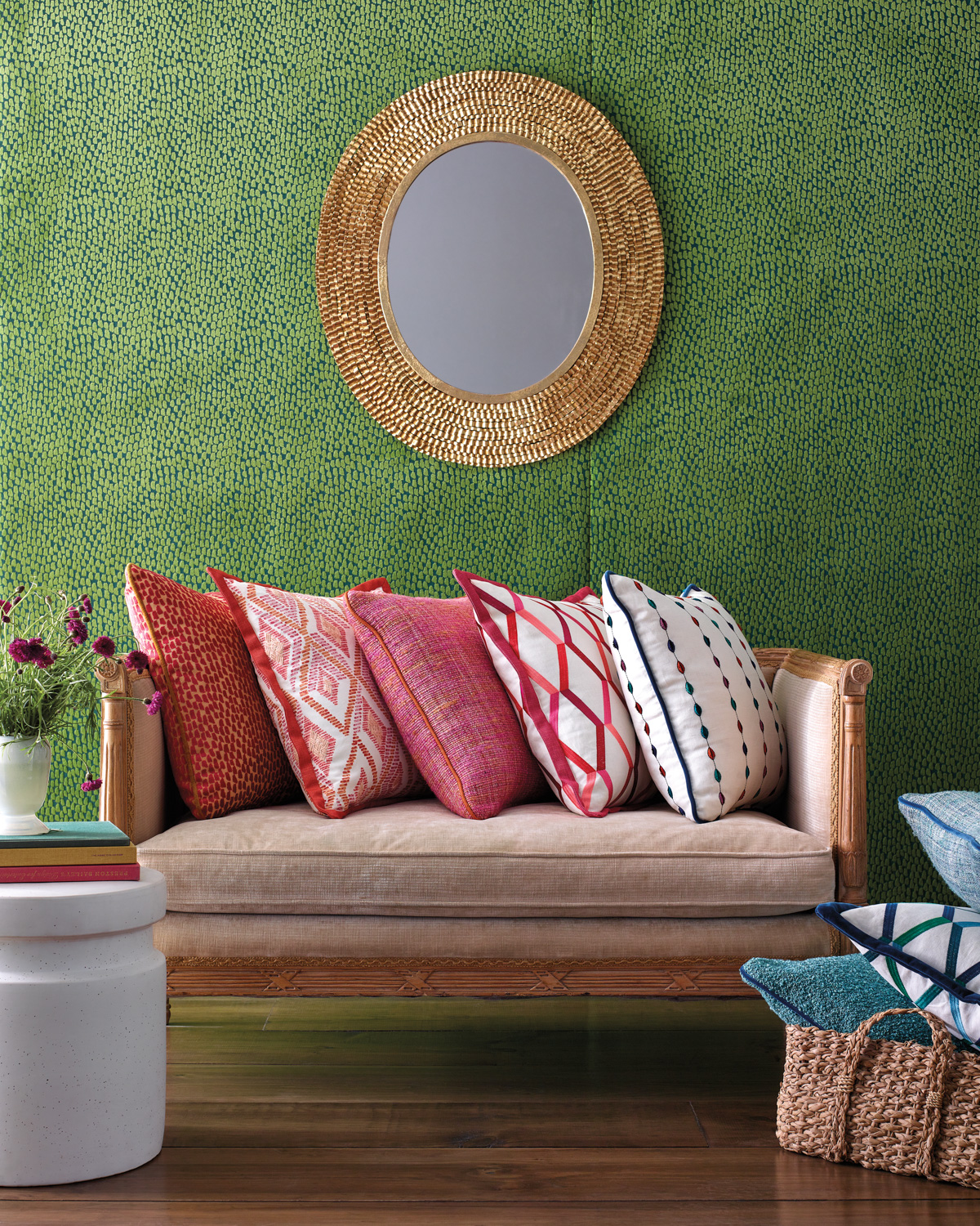 throw pillows in colorful patterned textiles on a sofa against a green wall