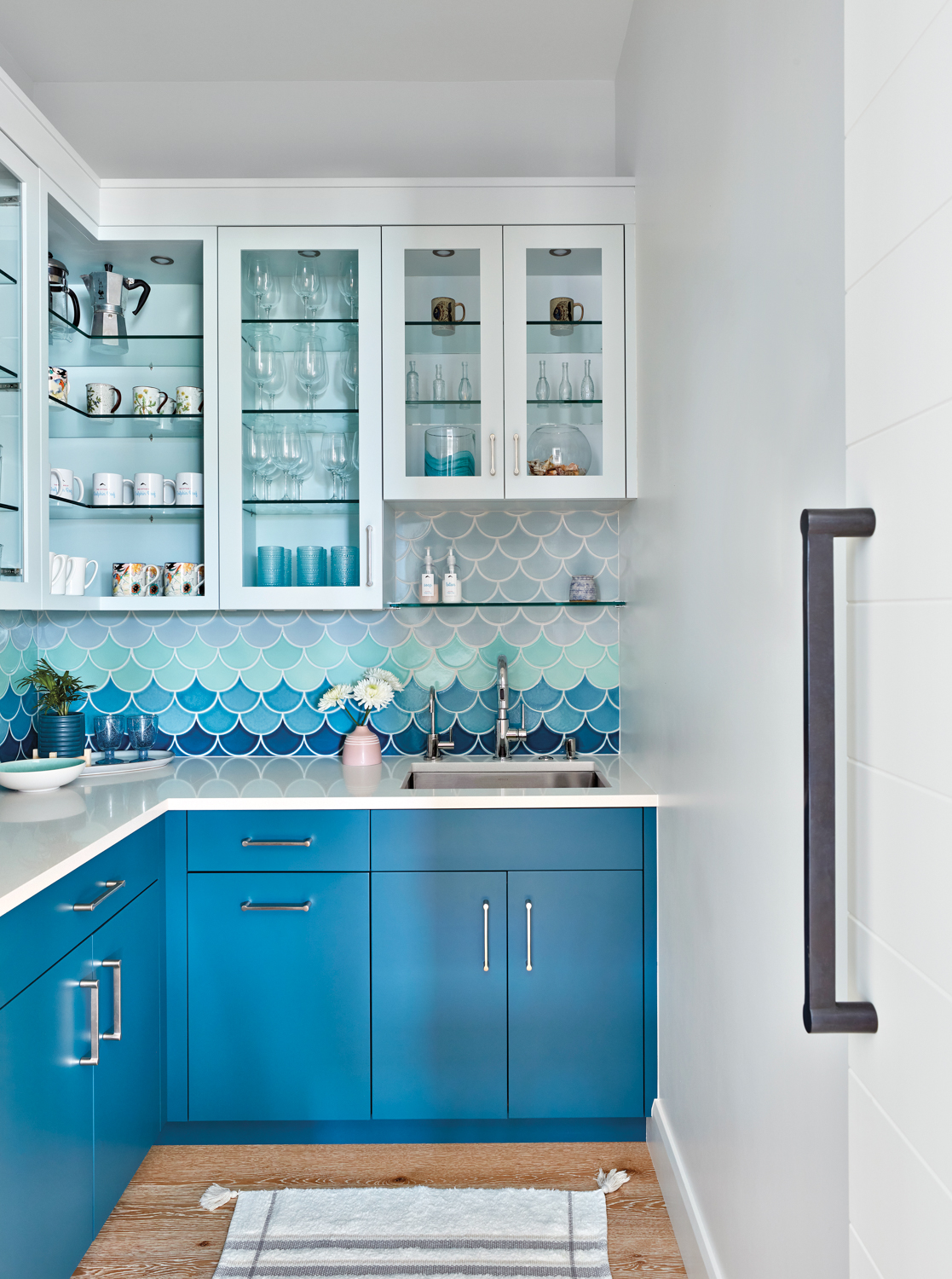 pantry with bright blue cabinetry,...