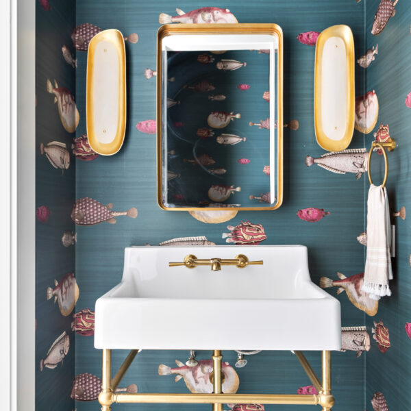 A ‘Forever Vacation Home’ Salutes The Splendor Of Anna Maria Island teal powder room with blowfish-print wallpaper, white vanity, mirror and oyster shell sconces