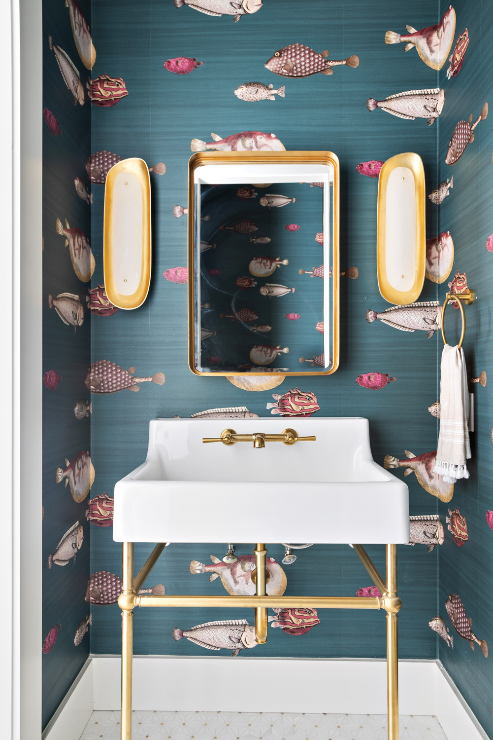 teal powder room with blowfish-print wallpaper, white vanity, mirror and oyster shell sconces