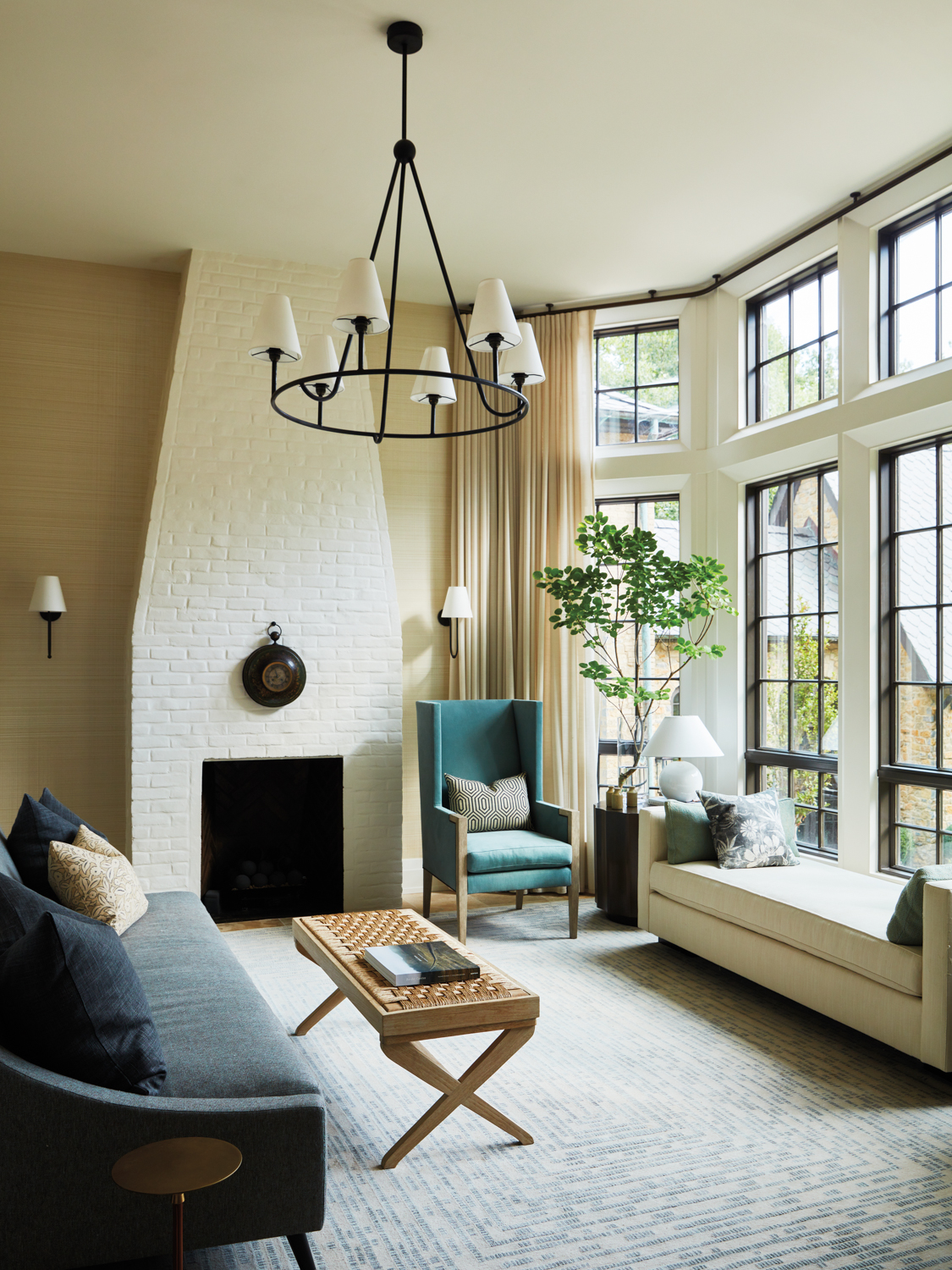 Sitting room with white painted brick fireplace, ring chandelier and daybed