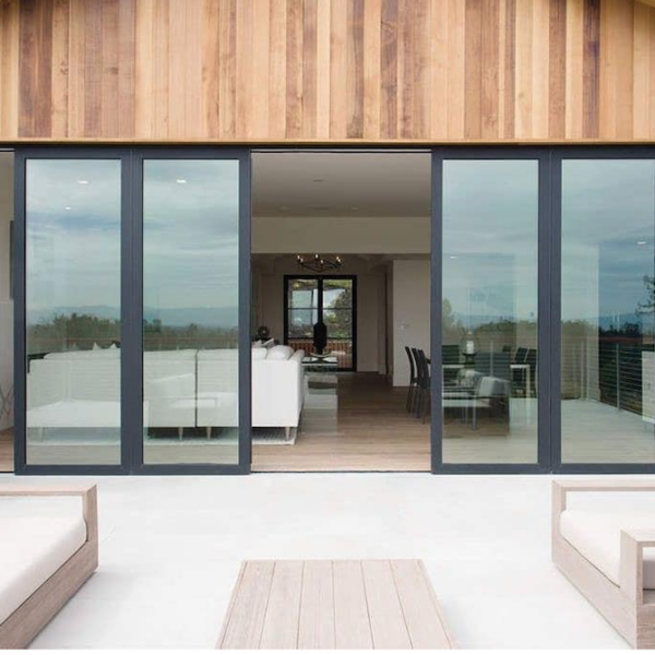 sliding glass doors open to patio with white outdoor furniture by Panoramic Doors