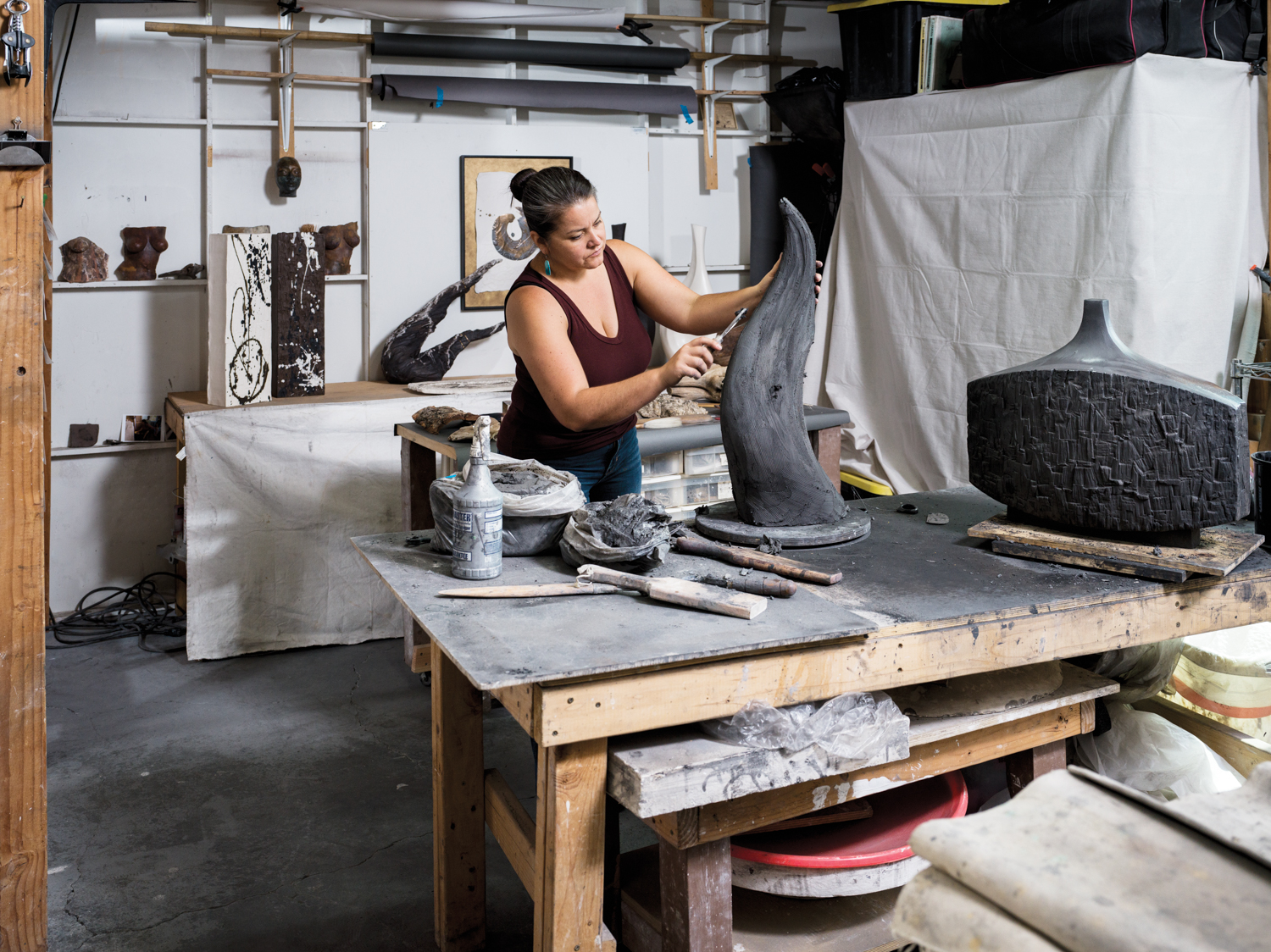 Sculptor Beverly Morrison working on a clay piece in her studio