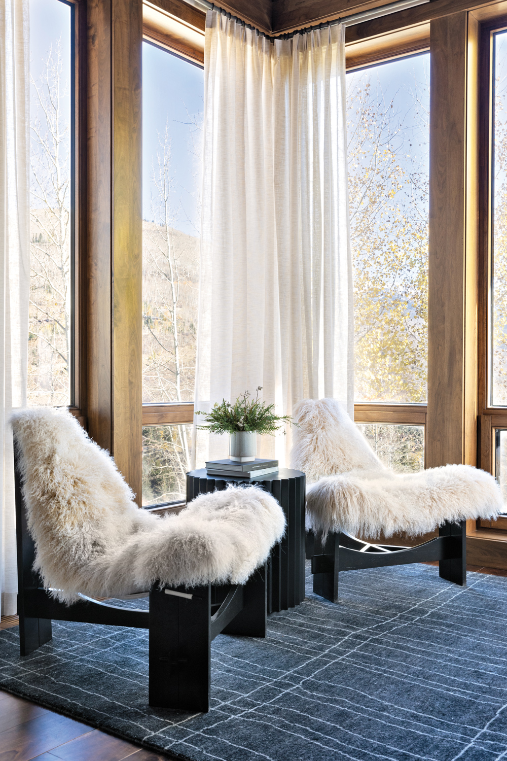 Two sheepskin-covered sling chairs against...