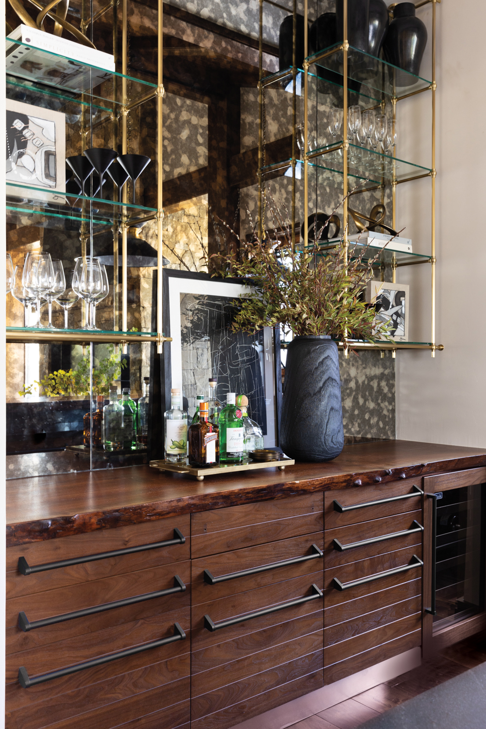 Bar with walnut cabinetry, brass-shelving...
