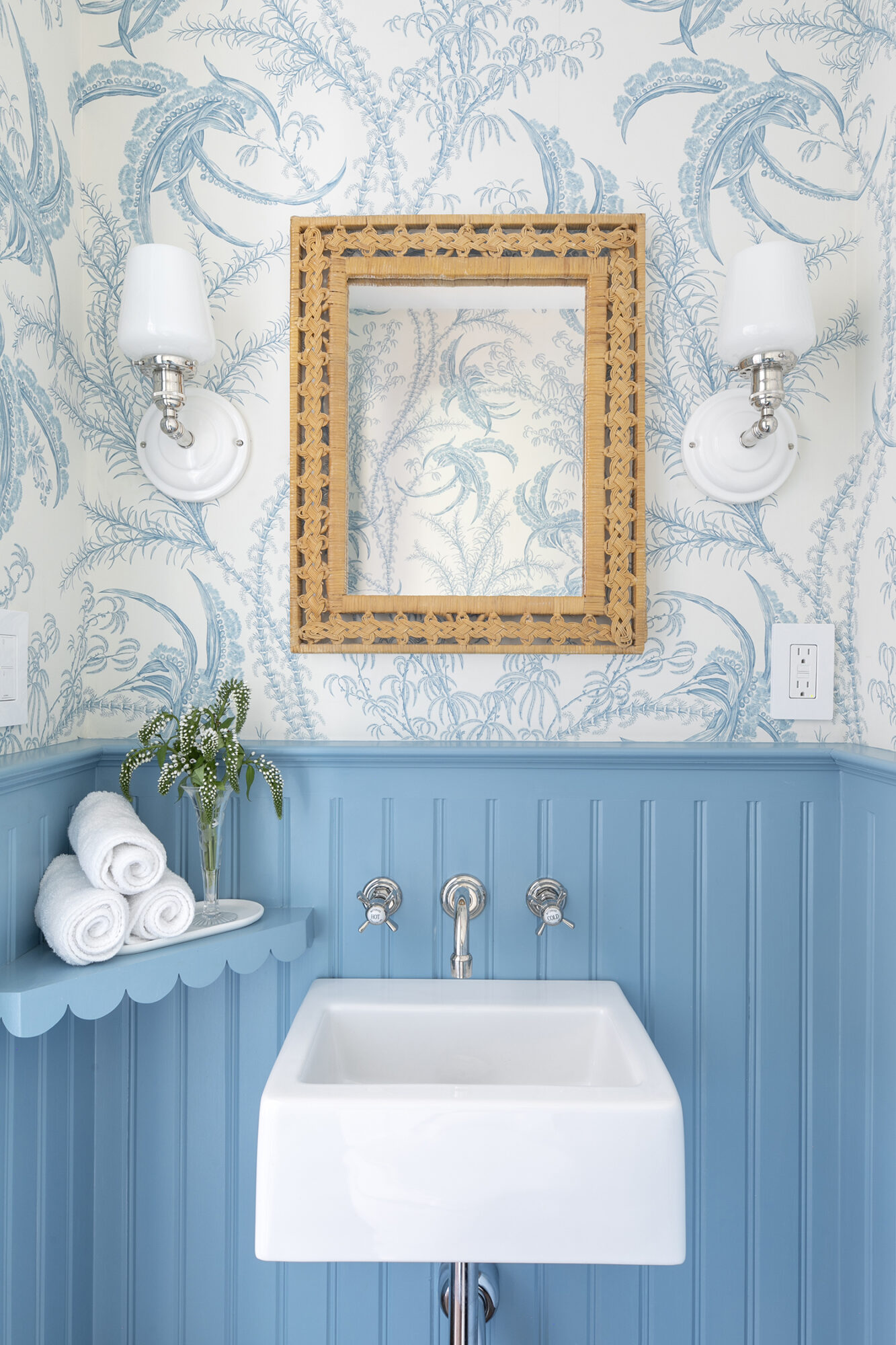 maximalist bathroom with blue paneling and blue and white palm wallpaper