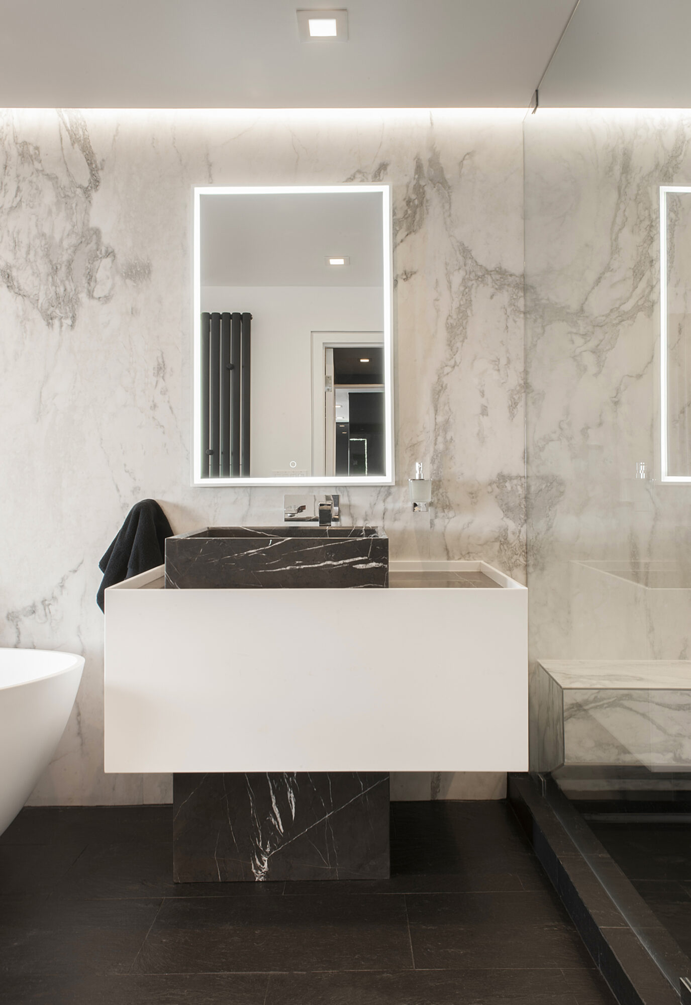 black and white modern vanity in bathroom with marble slab walls