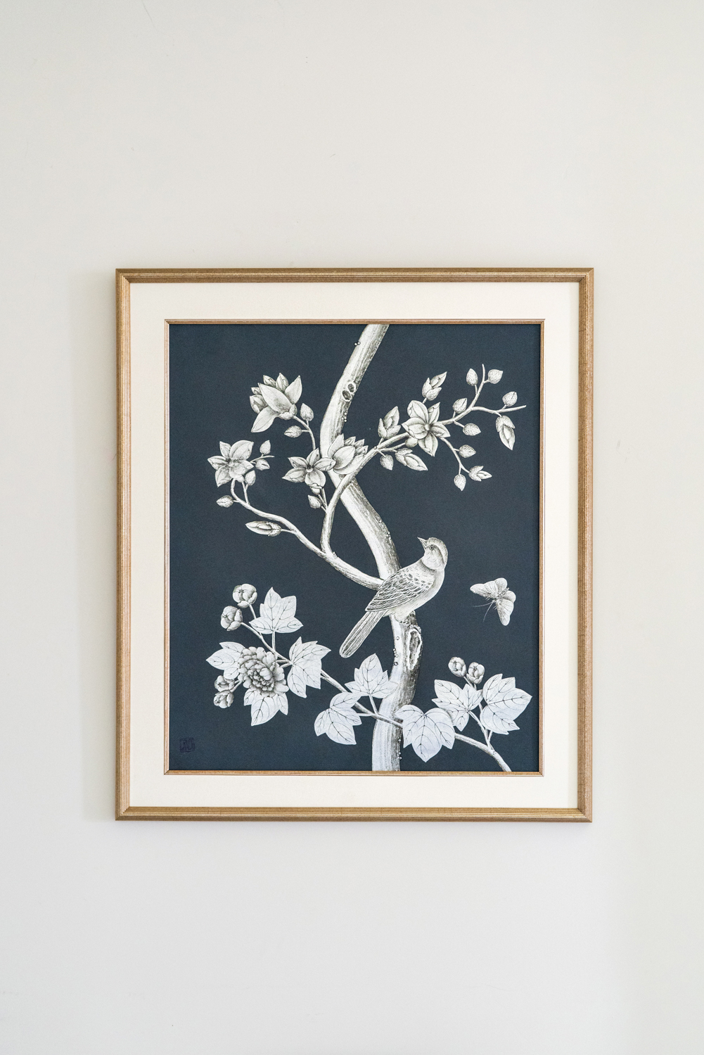 Framed white scenic floral with a bird resting on a branch hand-painted against deep blue