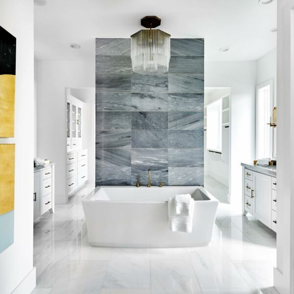Clean, white tiled bathroom with soaking tub.
