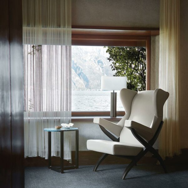 Cream colored arm chair sitting by the window.